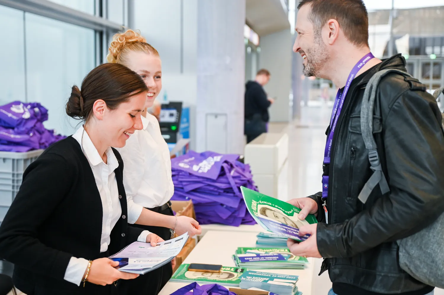 An exhibitor talking with visitors at a booth on the ECS expo floor