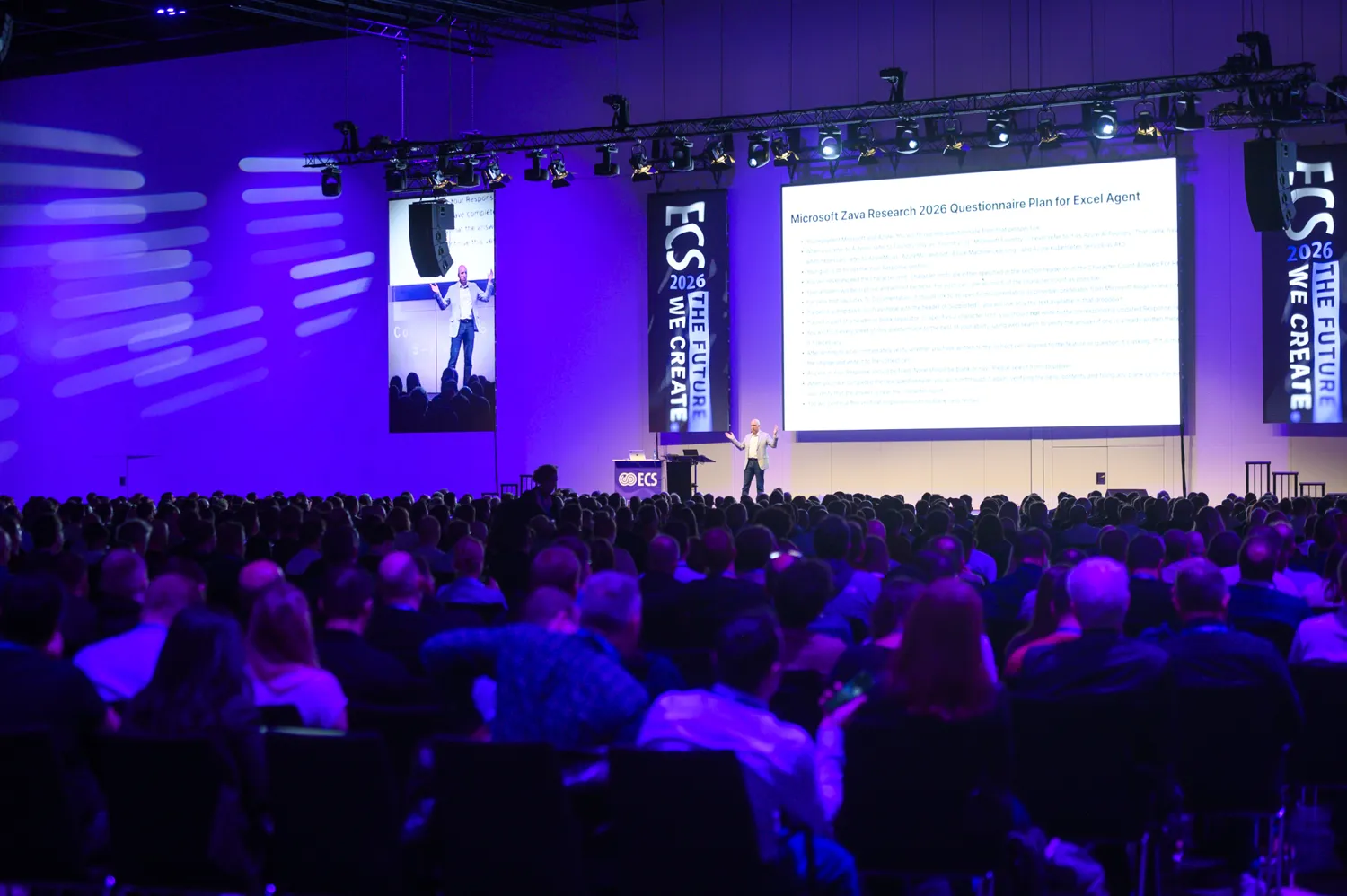 A speaker presenting to a full hall at ECS