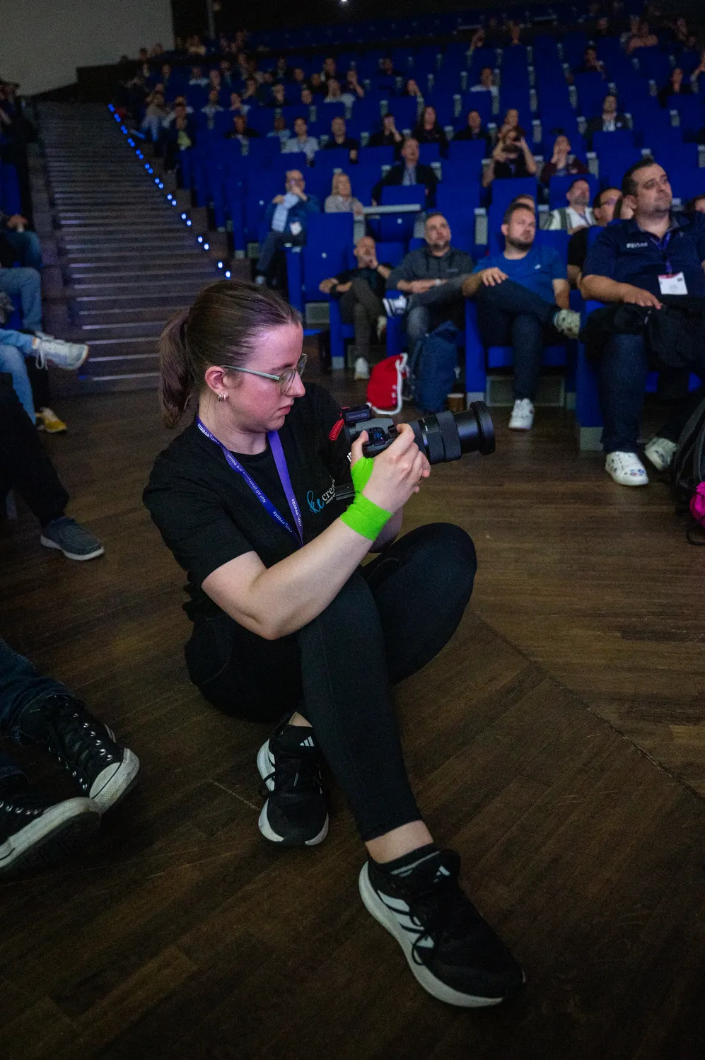 A photographer kneeling to capture attendees at ECS