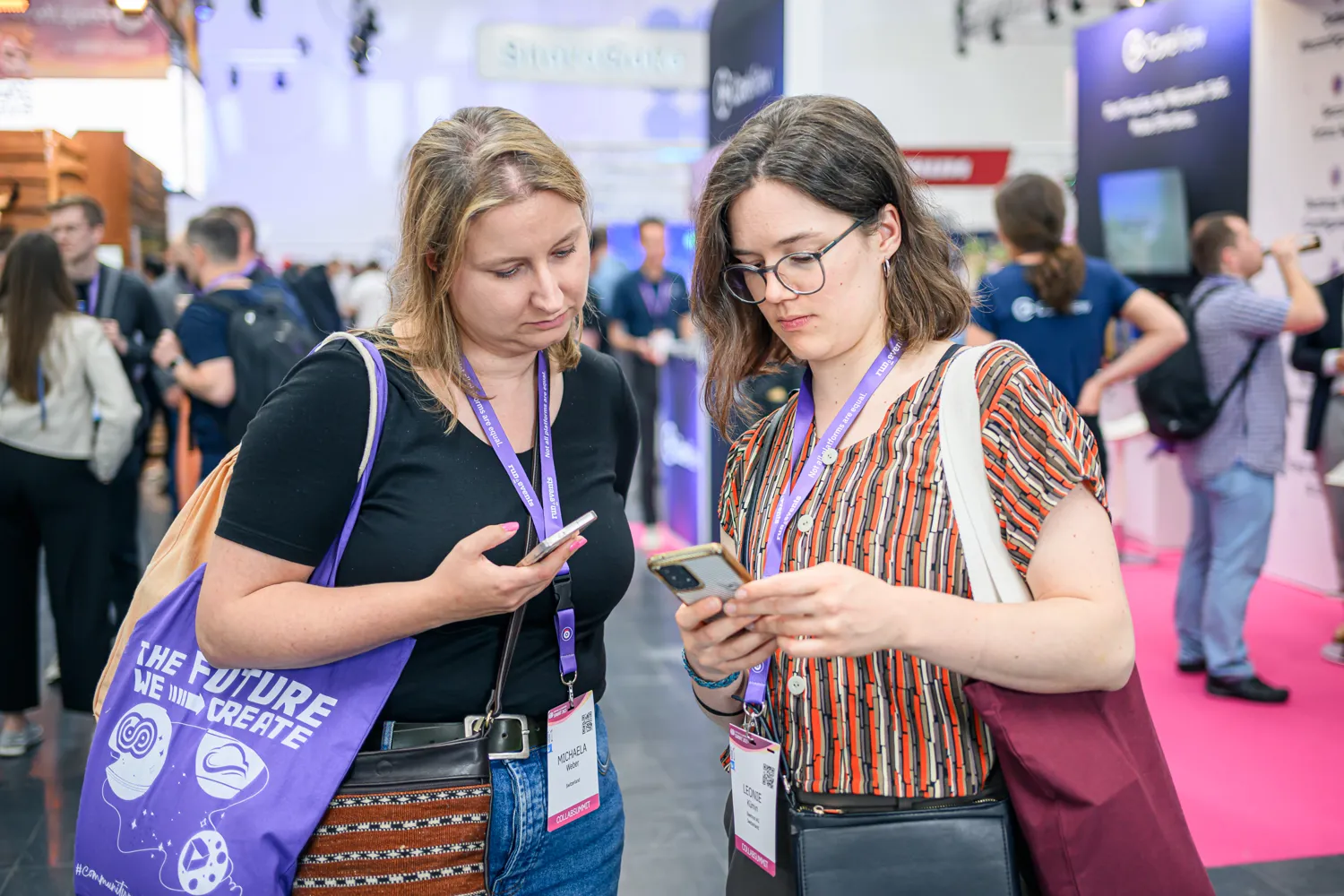 Two attendees looking at their smartphones at ECS