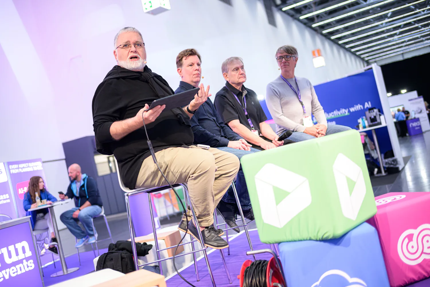 A panel discussion with four speakers on an ECS stage