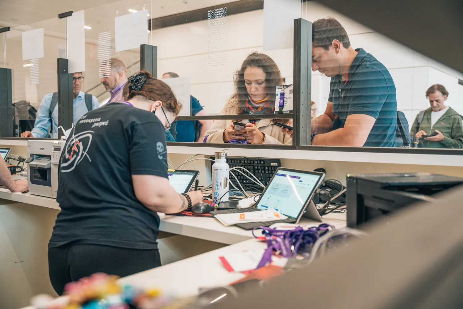 Attendees checking in and interacting at a registration counter during a technology event.