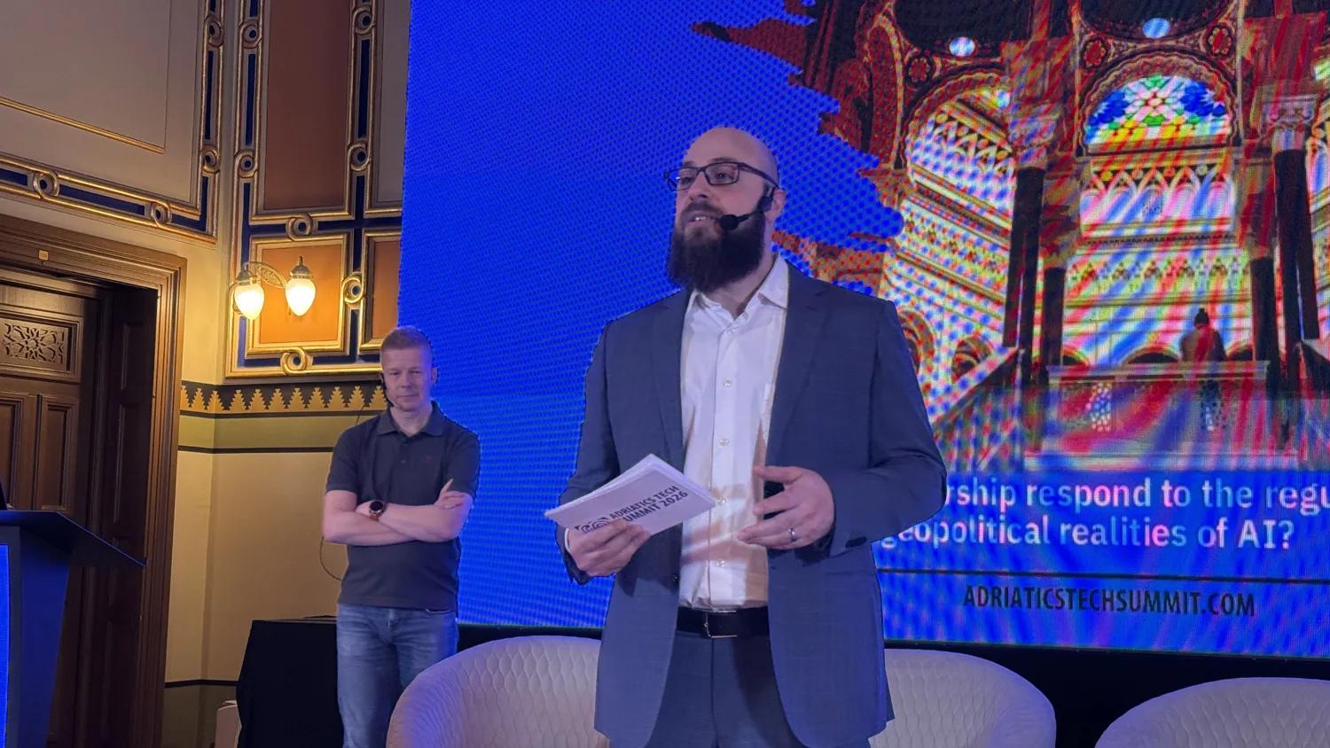 A speaker on stage discussing AI regulation