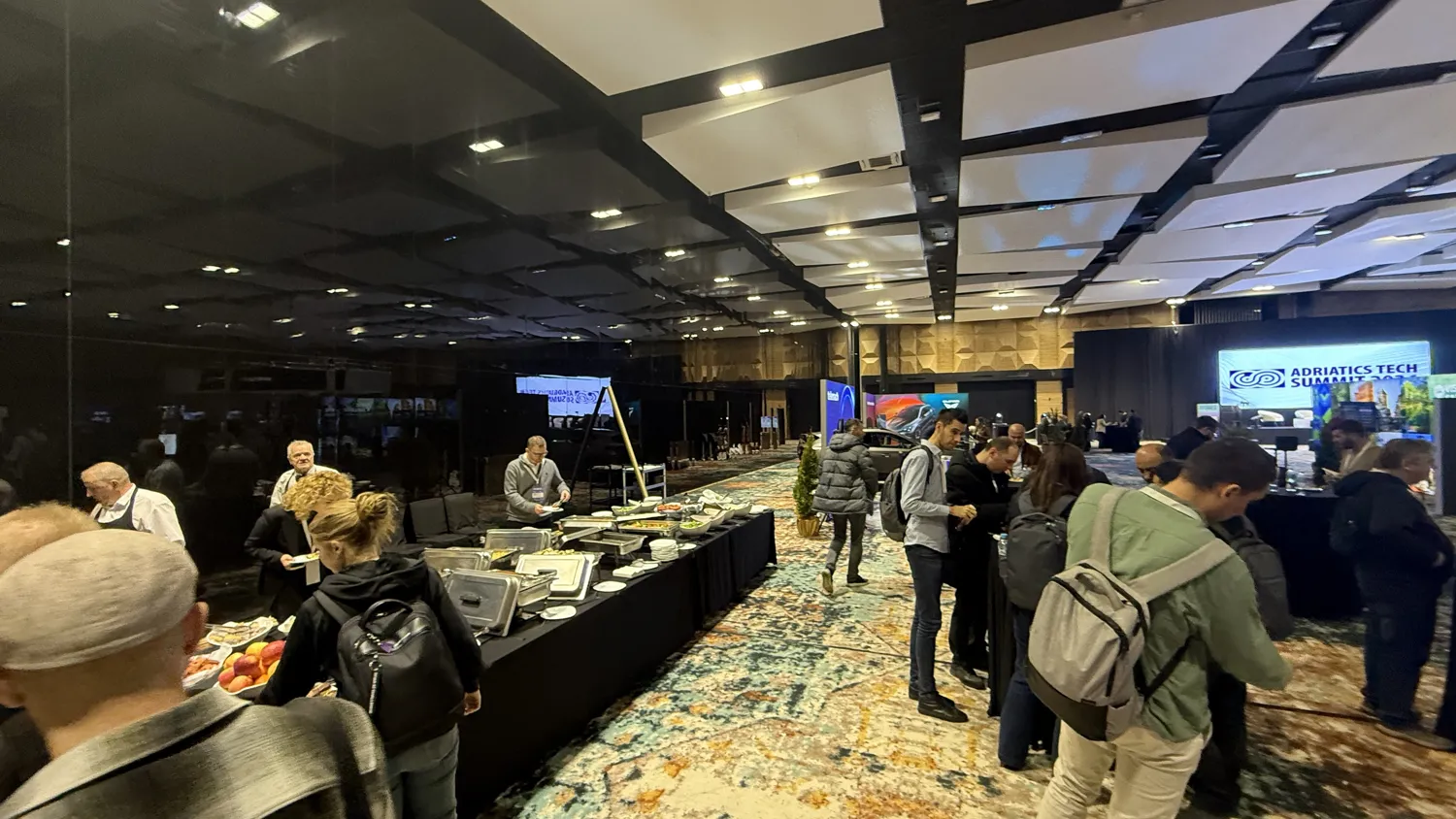 Delegates talking beside a stand between sessions