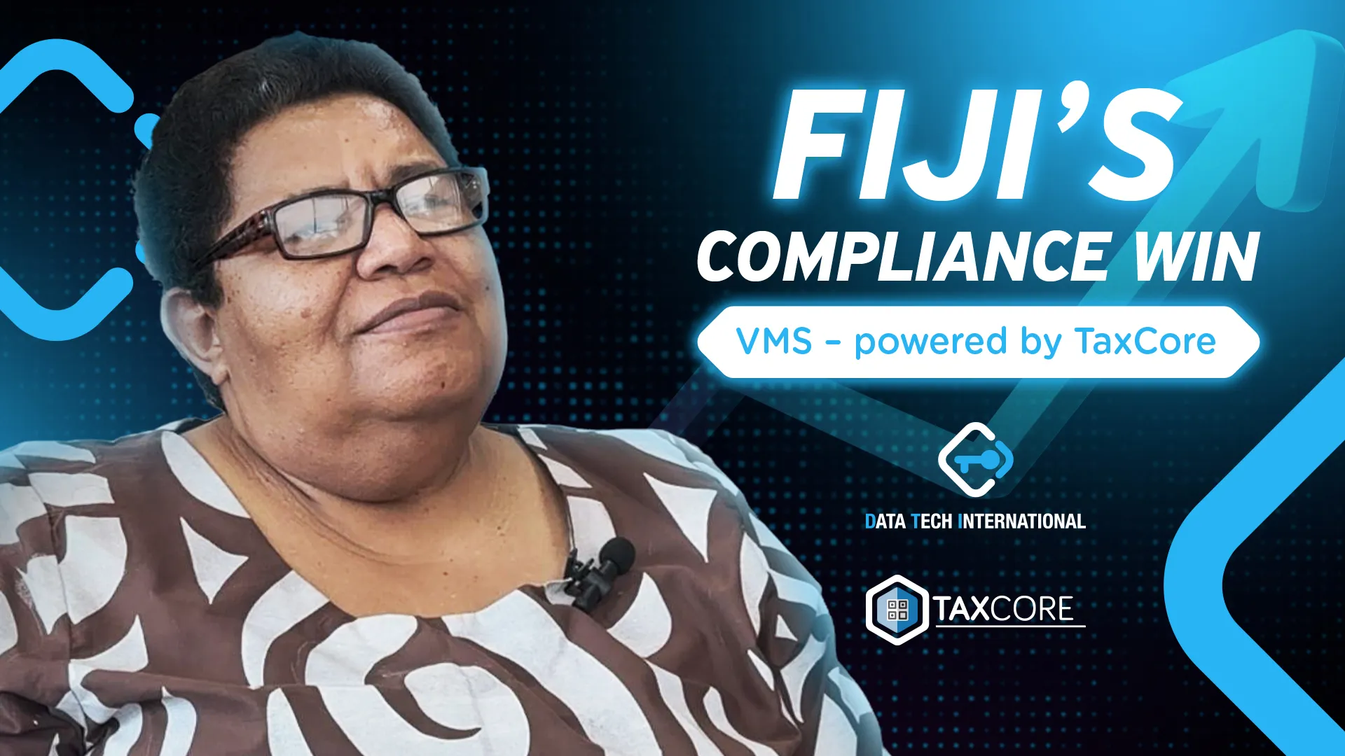 Professional individual wearing patterned traditional attire and glasses speaking or presenting against a modern background with text highlighting Fiji’s compliance win with VMS powered by TaxCore.