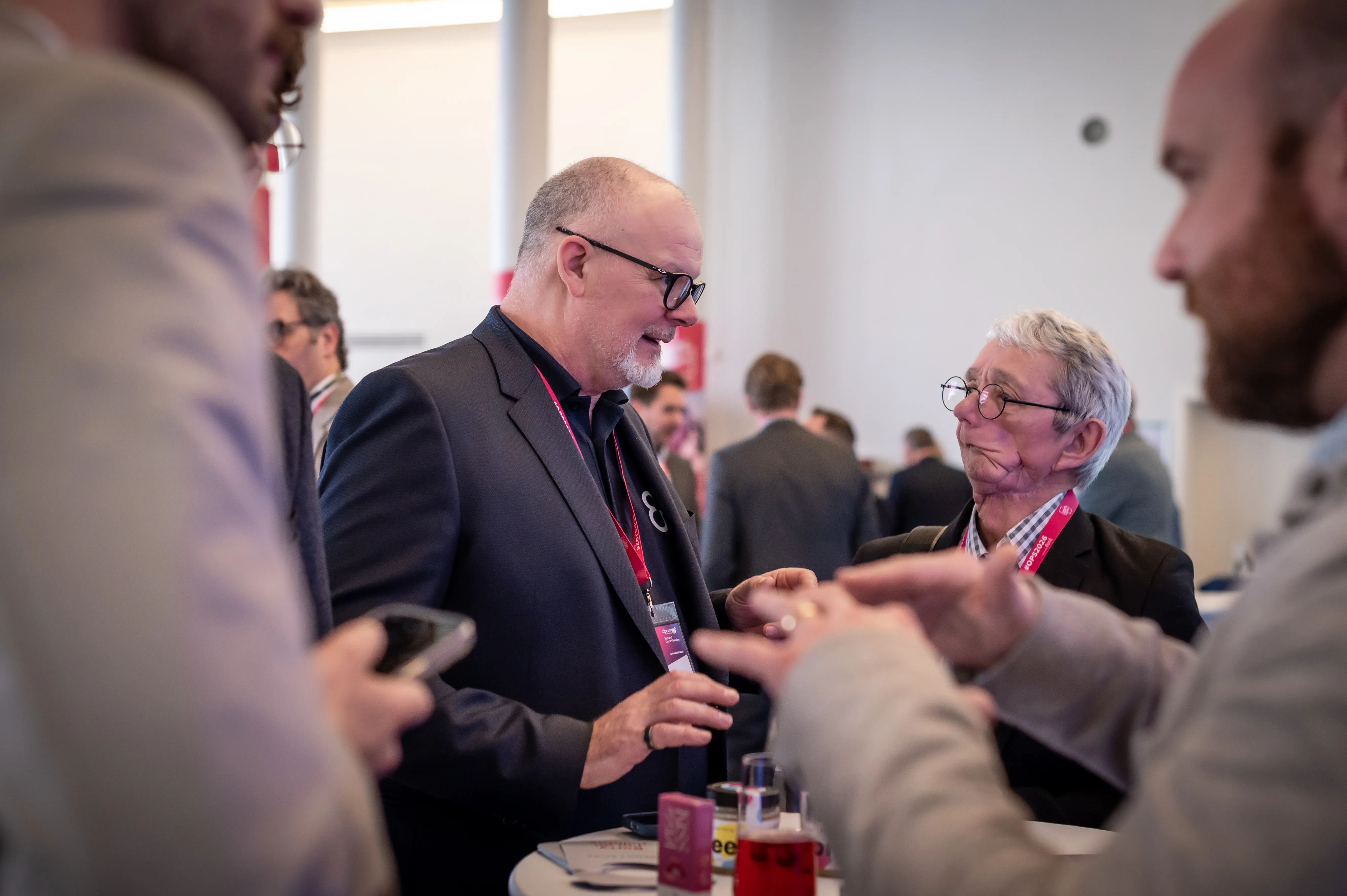 Two attendees in conversation at a partner stand of the Online Print Summit