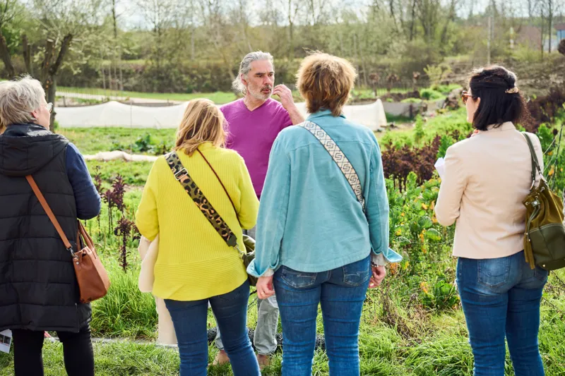 Menschen im GenussGarten zwischen Beeten und Natur bei einem gemeinsamen Tag.