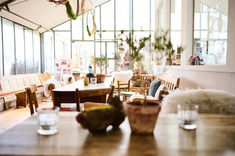 Schön gedeckte Tafel im GenussGarten mit Blick in den Raum und zum Garten.