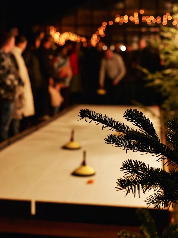 Festive table with candles and warm lights creating an evening atmosphere for Der GenussGarten leuchtet