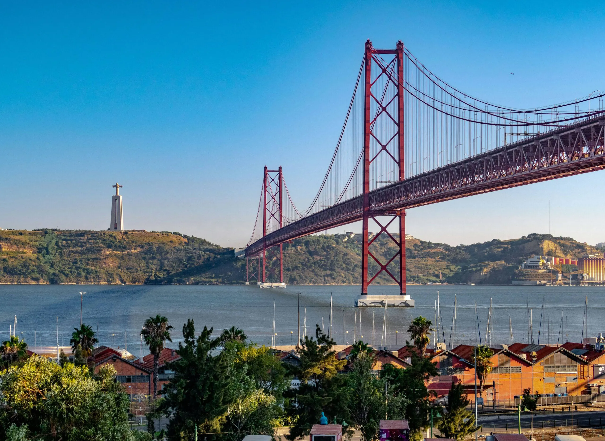 Lisbon waterfront with the red suspension bridge and the Cristo Rei monument